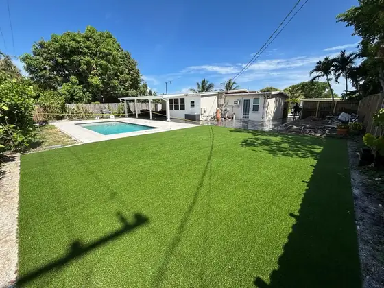 Artificial turf backyard next to a pool